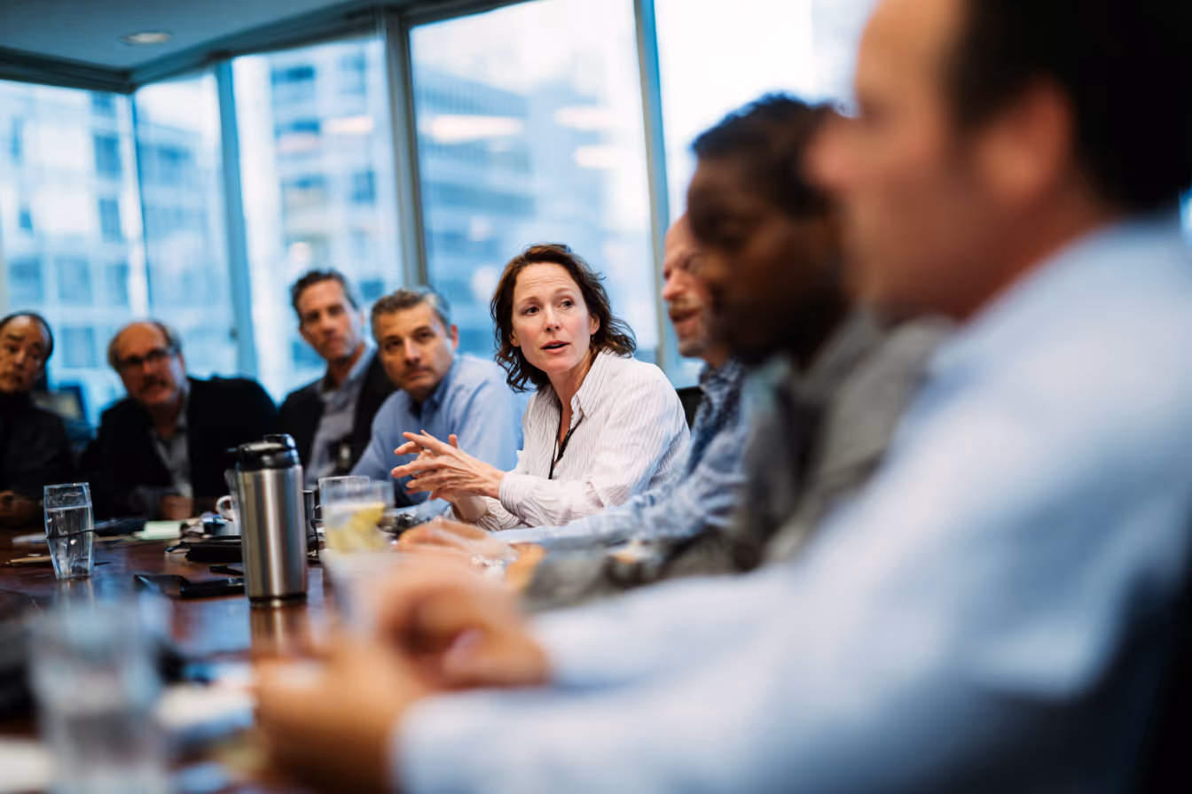 Group of professionals seated around a conference table in discussion during a CADSI committee meeting.
