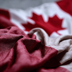 Close-up of a Canadian flag draped over documents representing national defence policy development.