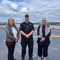Group of CADSI committee members standing together on an airport tarmac near aircraft.