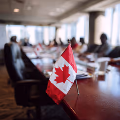 Meeting room with a small Canadian flag on the table during a defence policy discussion.