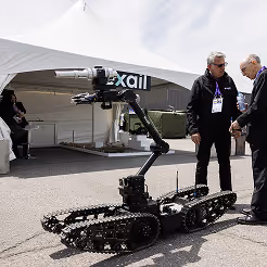 Military personnel operating an unmanned ground vehicle during a cybersecurity and robotics demonstration.