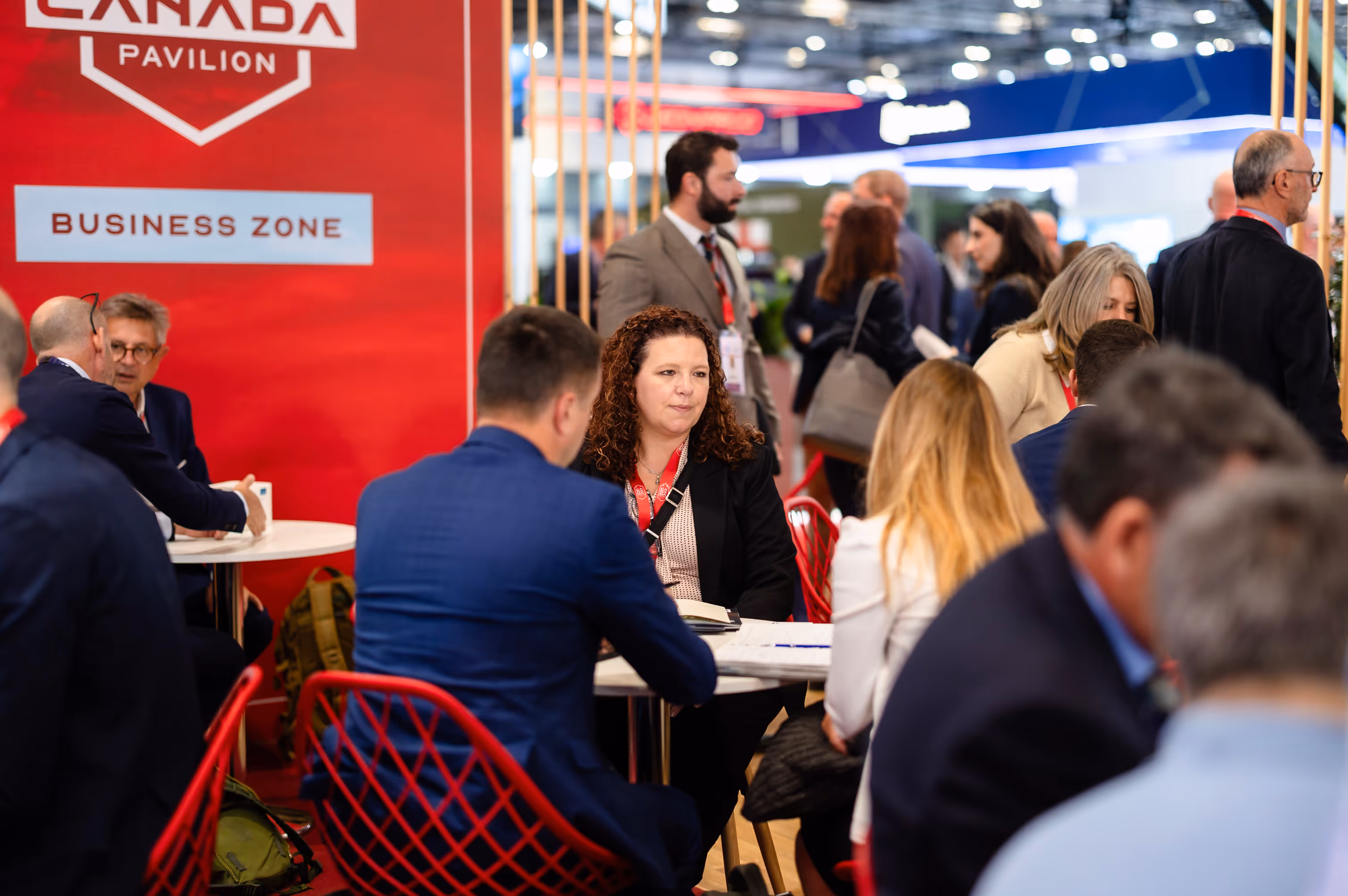 People talking in the Canada Pavilion Business Zone at an earlier international event.