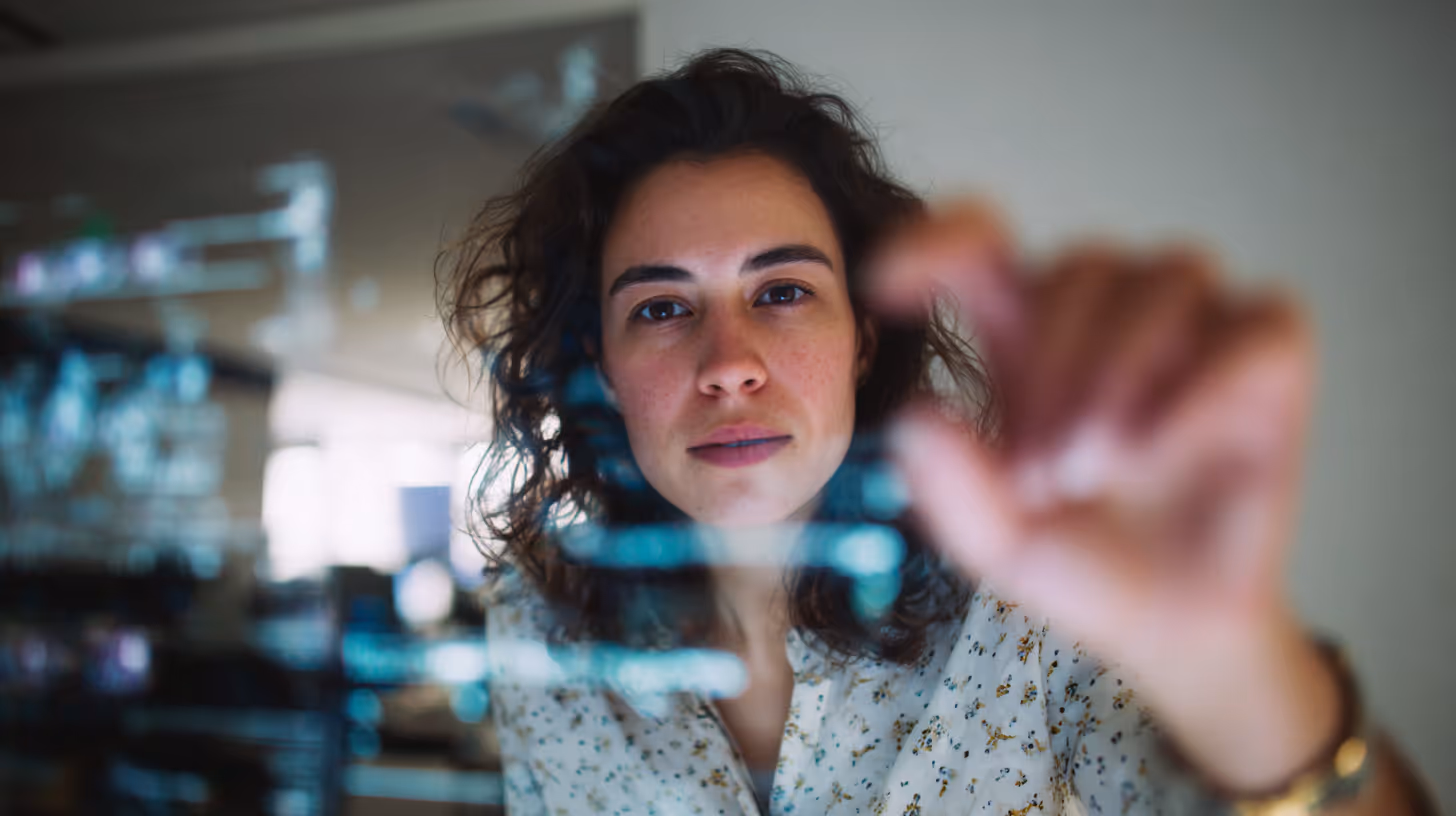 Engineer drawing on transparent digital interface in a modern workspace.