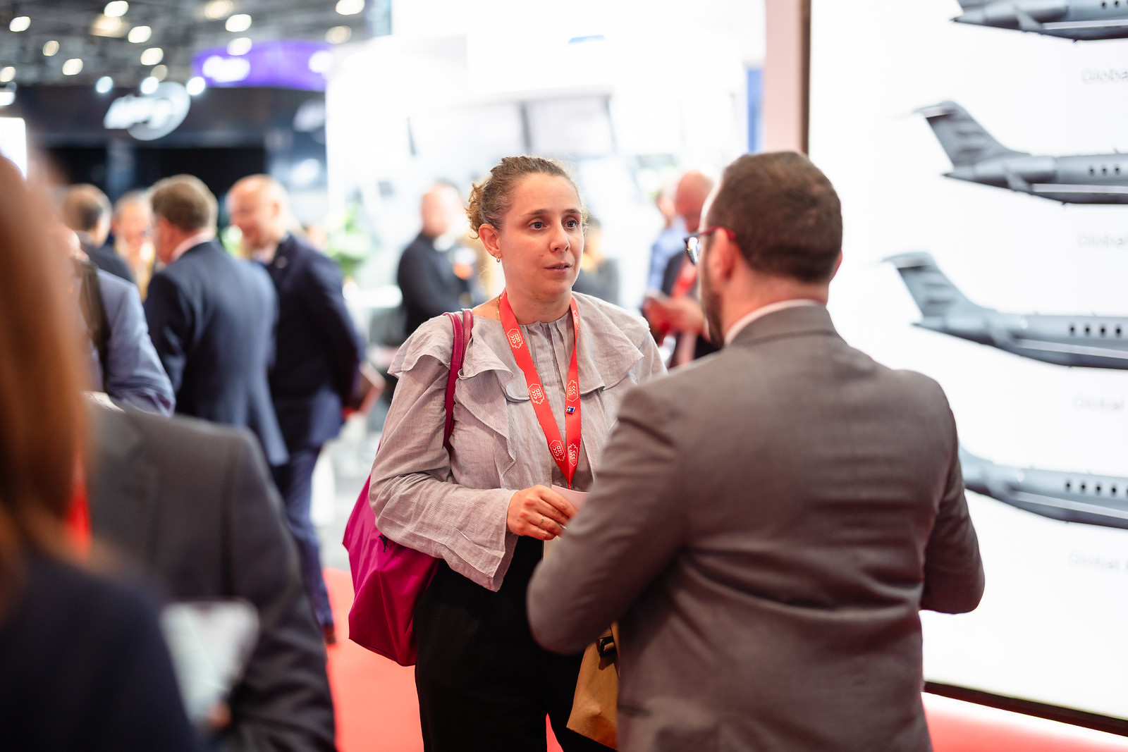 Two attendees talk face to face on the DSEI UK exhibition floor.