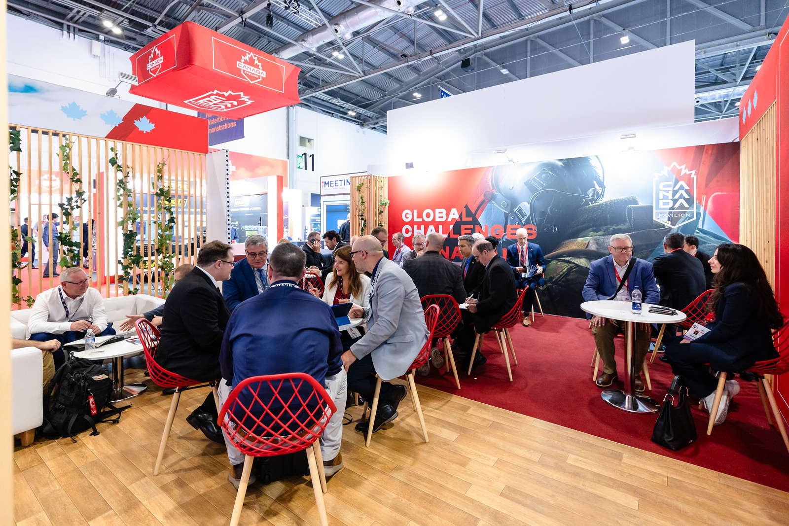 Visitors meet beneath Canada signage in the Canada Pavilion at DSEI UK 2025.