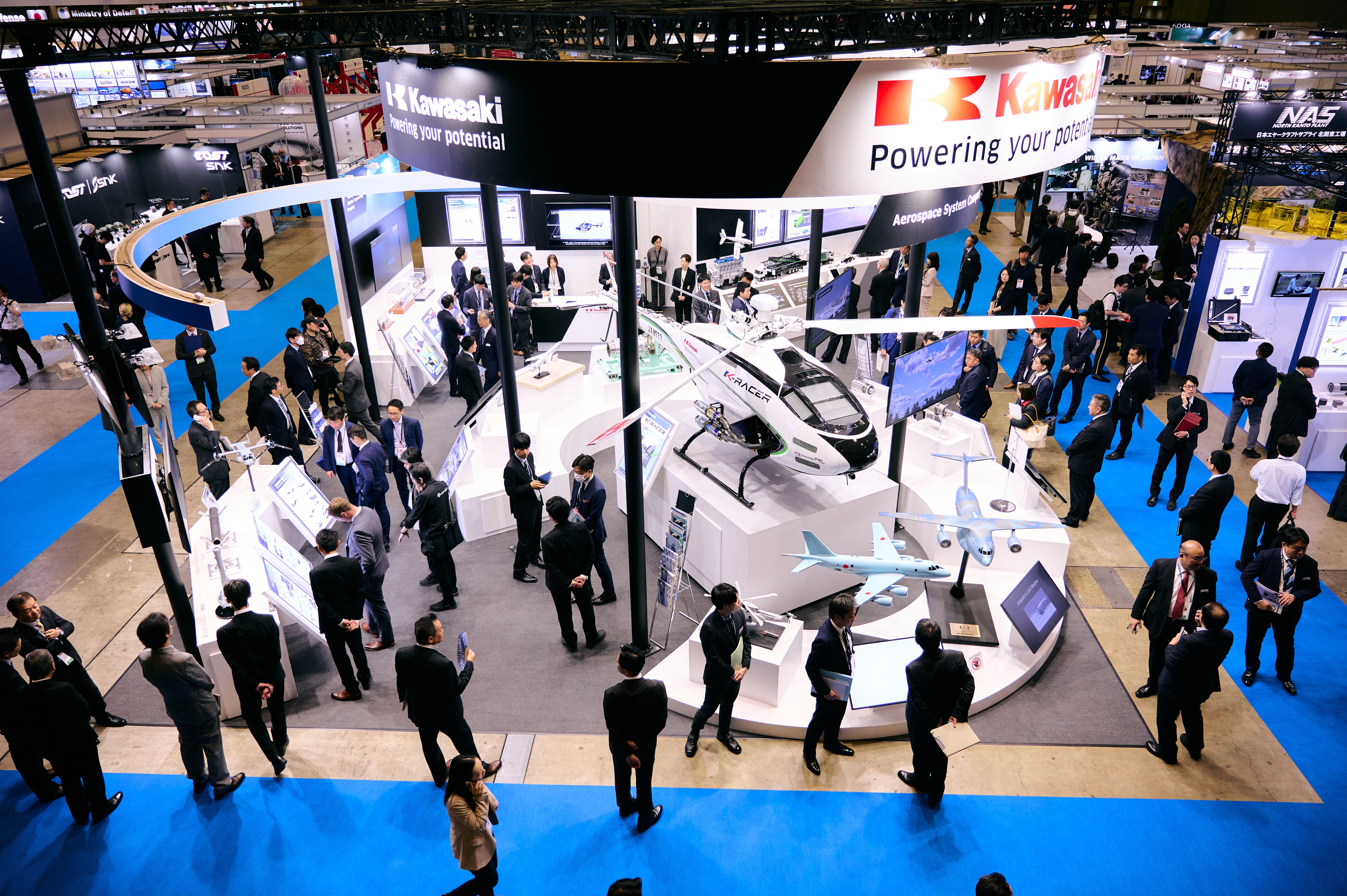 Visitors at a Kawasaki exhibit at DSEI Japan 2025.