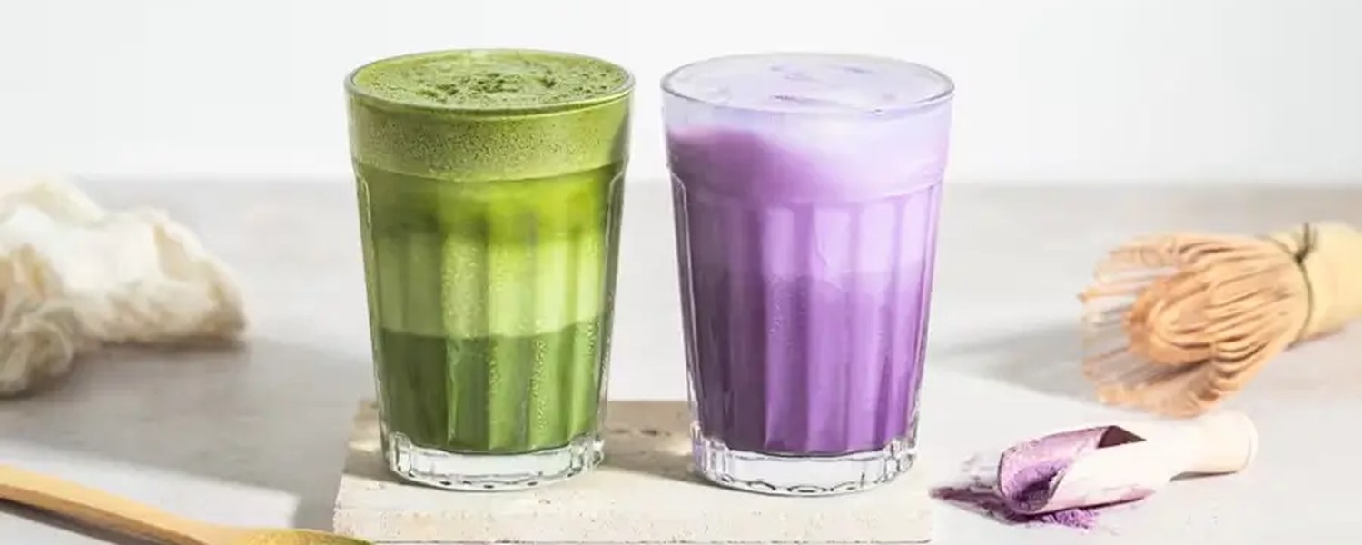 Préparation maison d’un ube latte avec poudre violette et lait sur fond beige