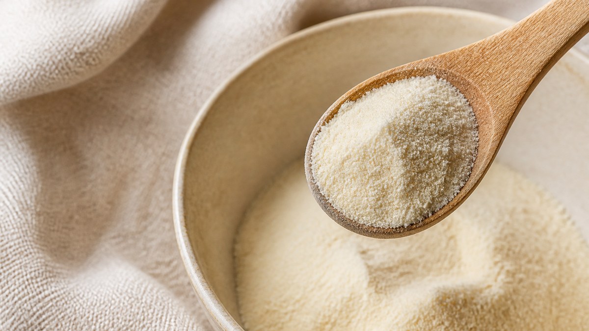 Colostrum en poudre dans une cuillère en bois