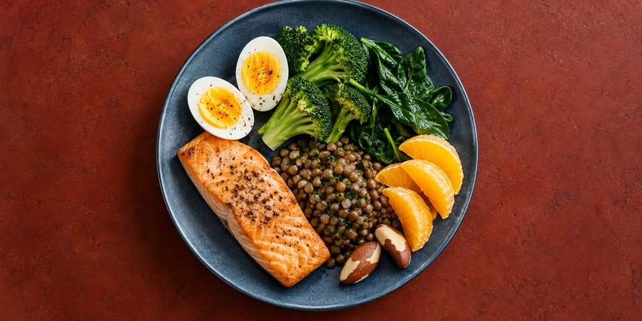 Assiette d'automne avec poisson gras, œuf, légumes verts, légumineuses et agrumes