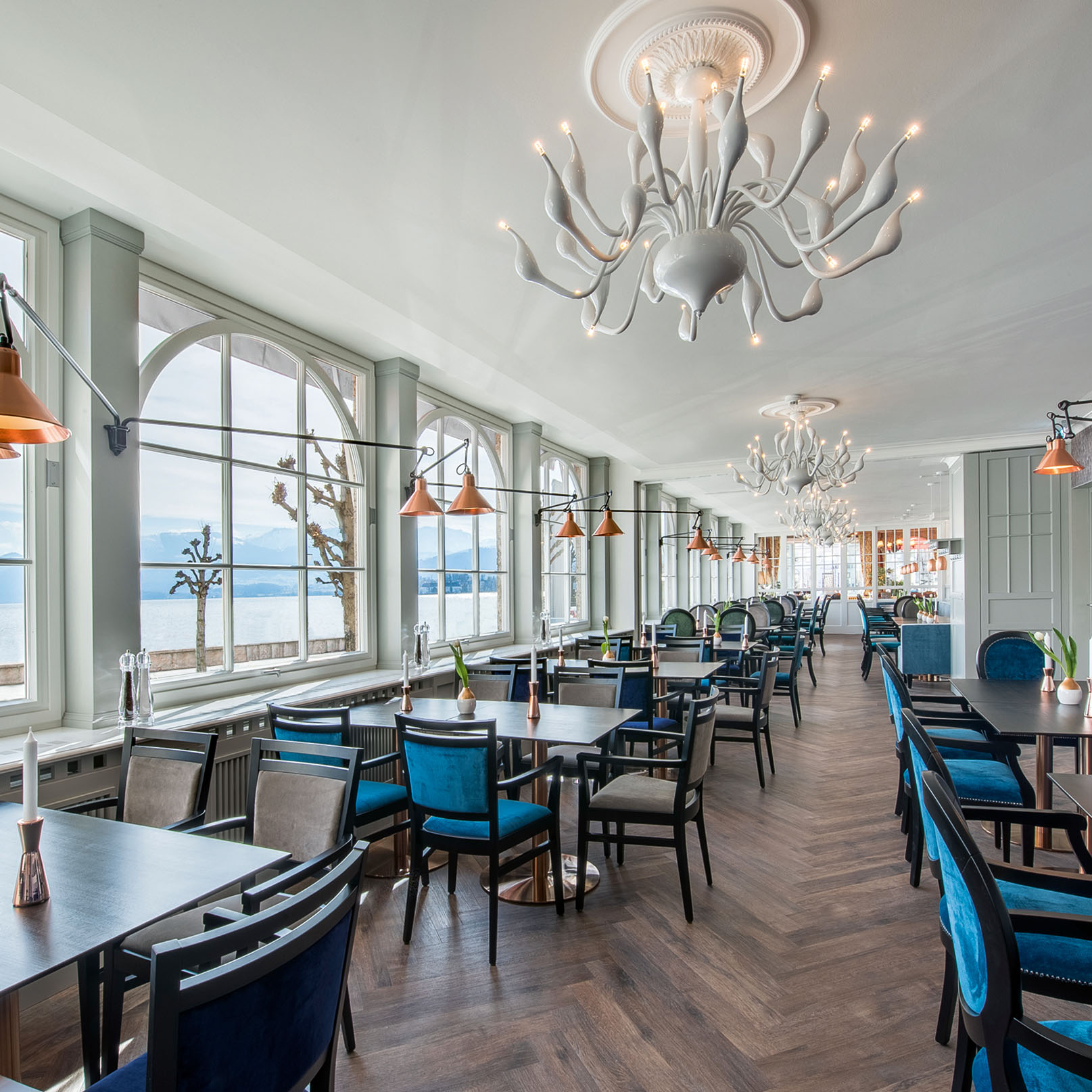 Ein moderner Speiseraum mit türkisen und grauen Stühlen