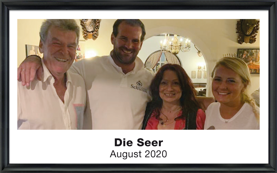 Alvaro Soler steht zwischen zwei Frauen vor einem Baum und lächelt in die Kamera, Foto aus Mai 2022.