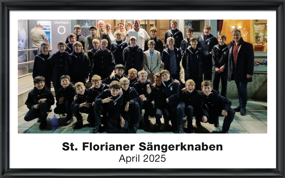 Gruppenfoto der St. Florianer Sängerknaben mit etwa 30 Jungen und mehreren Erwachsenen vor einem Gebäude, aufgenommen im April 2025.
