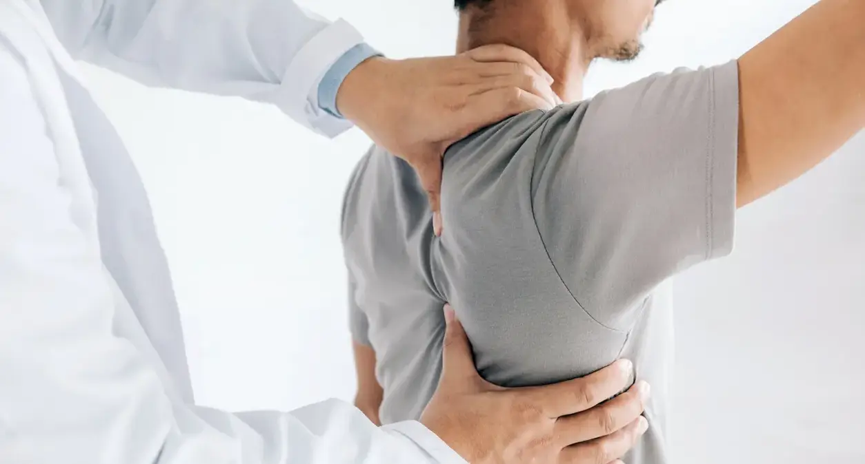 Athlete holding their lower back after a sports-related spine injury