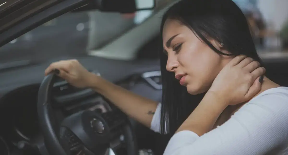 Person holding their neck after a car accident, a potential sign of nerve irritation