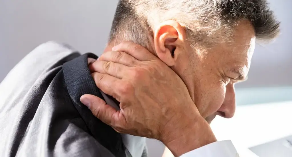 Person holding the shoulder and collarbone area where thoracic outlet syndrome can compress nerves or blood vessels