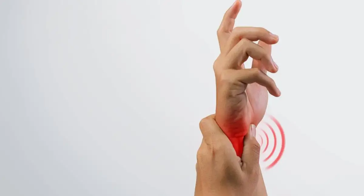 Person gently supporting their wrist and palm after carpal tunnel release surgery during early recovery