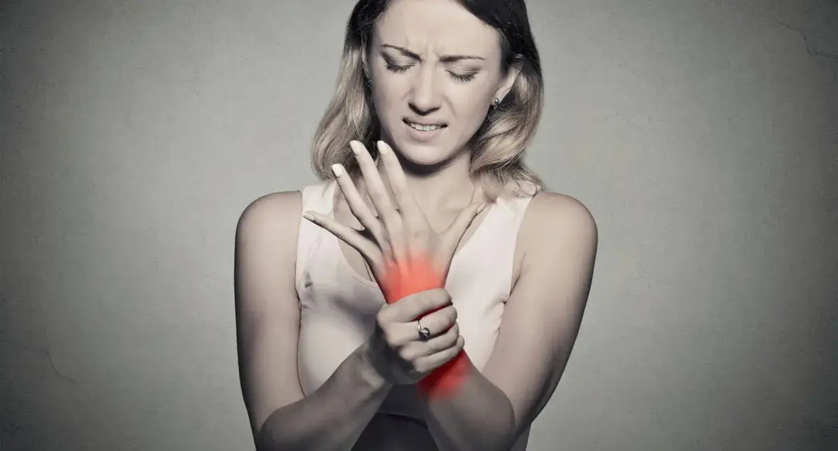 Person holding their wrist with radiating pain and tingling consistent with nerve irritation