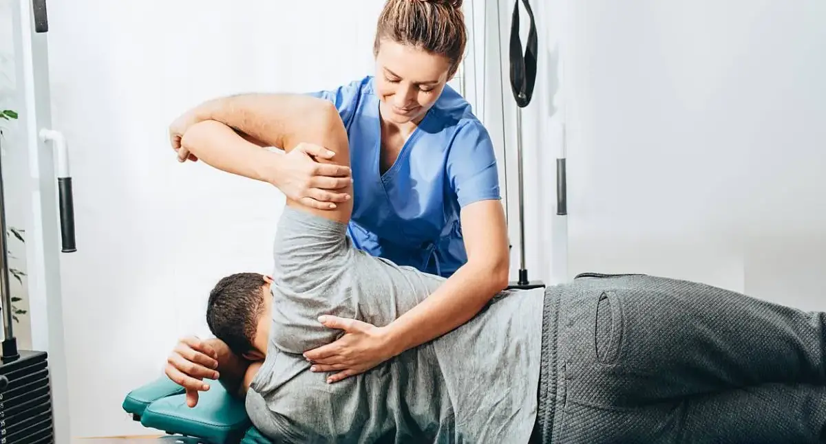 Physical therapist guiding a patient through back-strengthening exercises for herniated disc symptoms