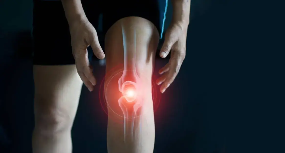 Person holding their lower back, a common area affected by spinal osteoarthritis