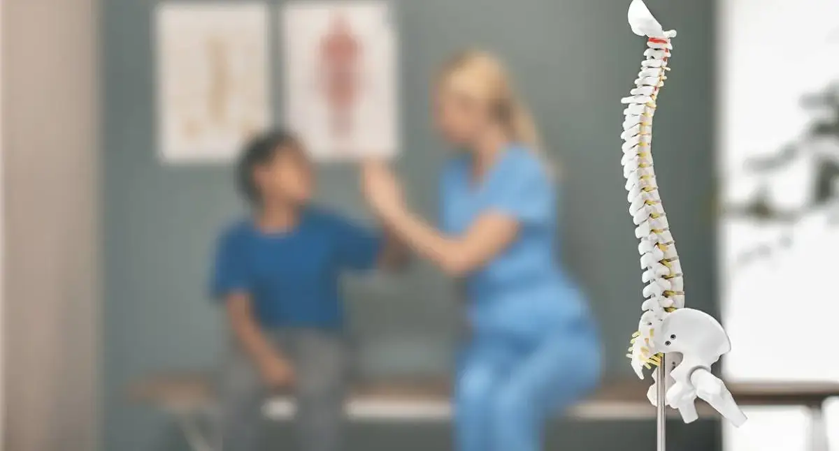 Doctor evaluating a child’s back pain with a parent present in the exam room
