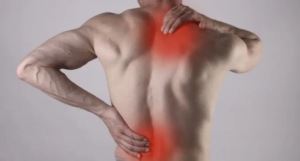 Adult holding their lower back during a sudden painful back spasm