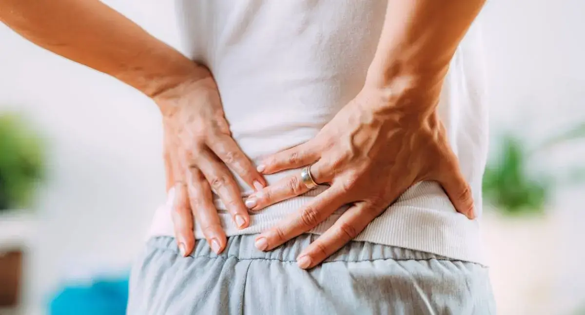 Person doing a gentle hip stretch on a mat to reduce sciatic nerve pain before exercise