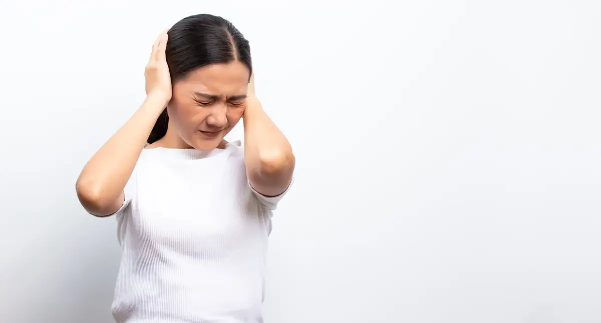 Person holding their head in pain, representing severe headache warning signs that may need urgent medical evaluation