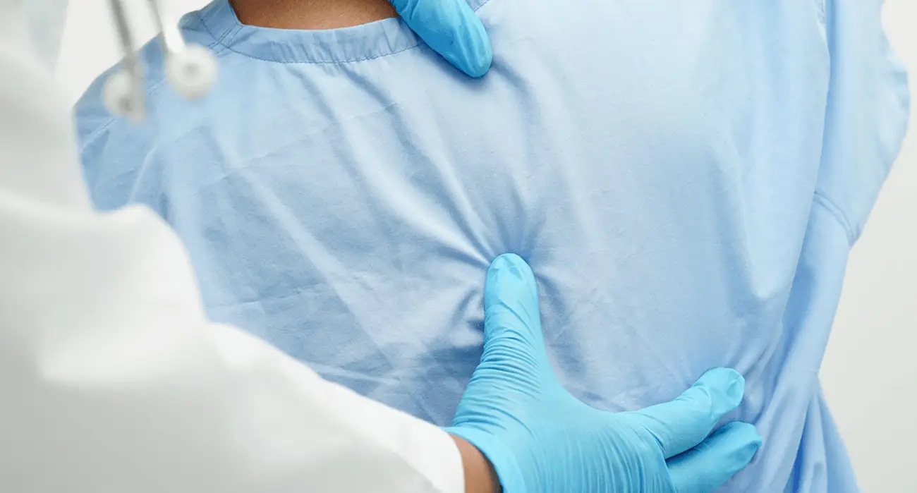 Spine specialist evaluating a patient with lower back disc pain during an exam in Los Angeles.