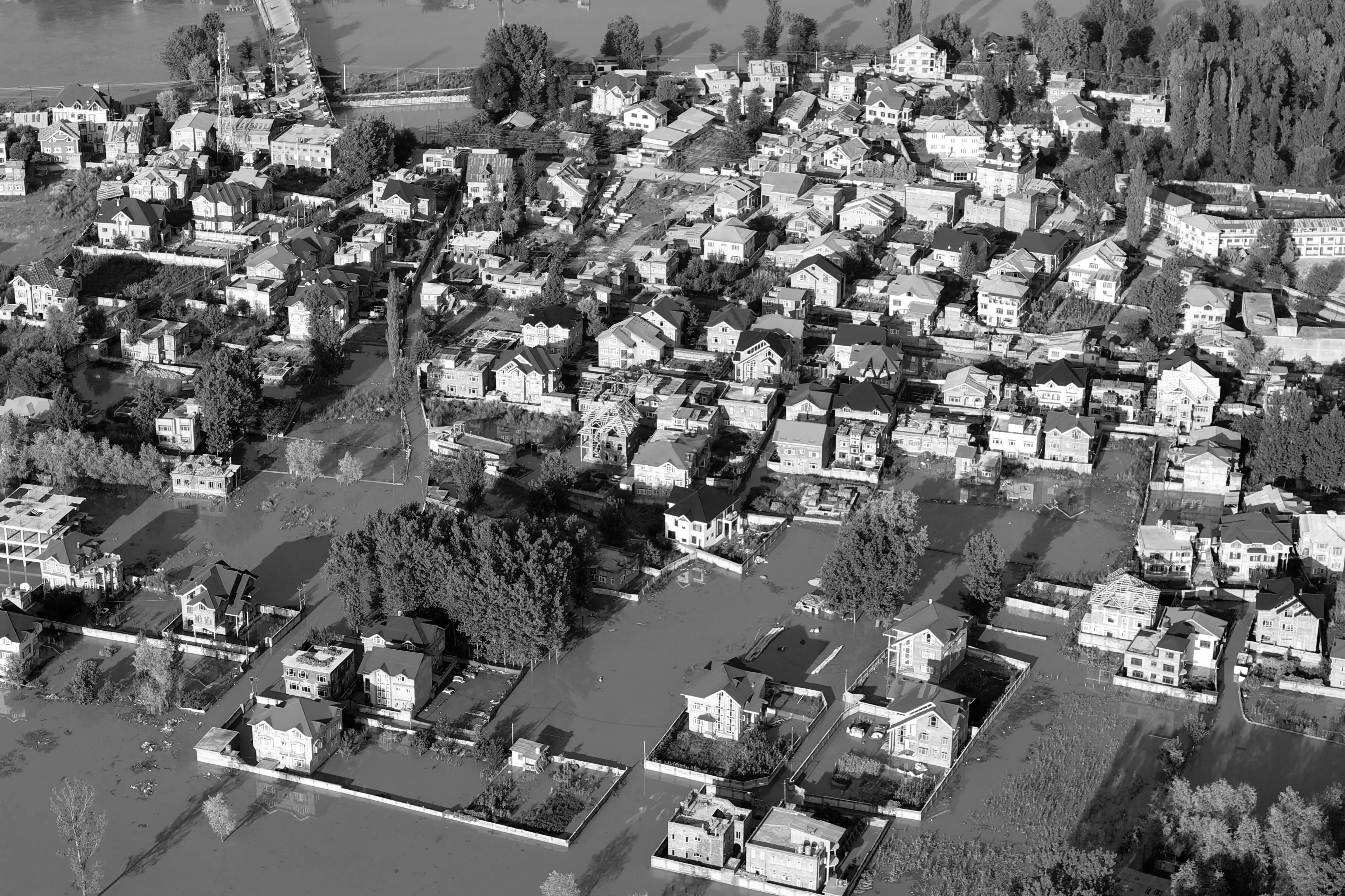 Aerial view of a residential neighborhood flooded with water surrounding houses and streets.