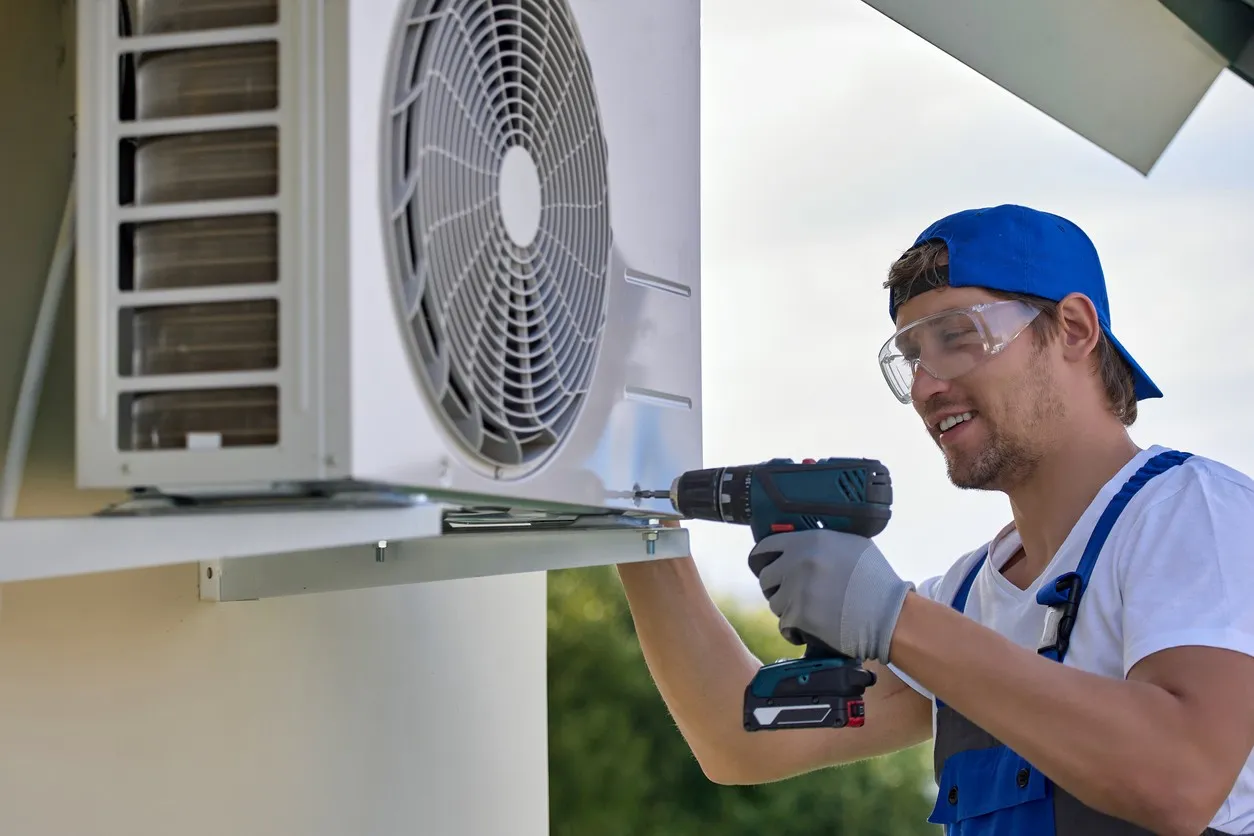 A  technician Working with his drill and wearing blue Cap