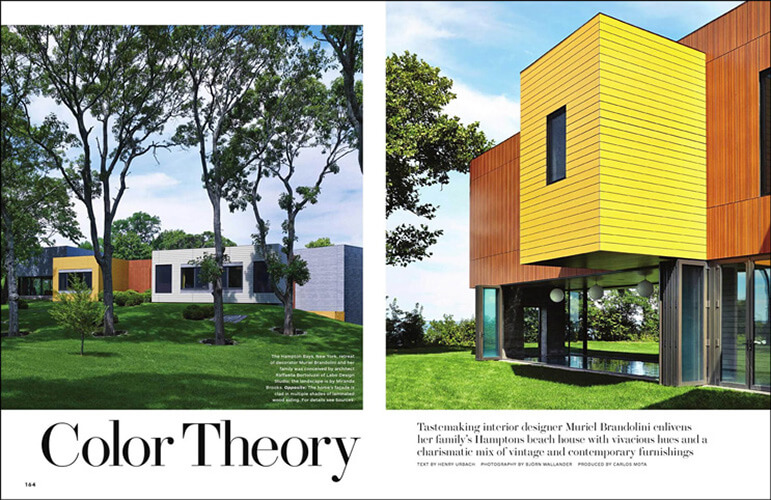 Magazine article featuring CNR Group luxury home construction project: Modern Hamptons beach house with bold yellow and orange exterior accents surrounded by green lawn and trees.