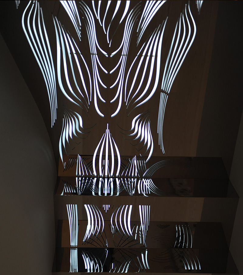 Abstract metalwork light installation with curved white neon lines reflected on glossy black horizontal panels in a dark space.