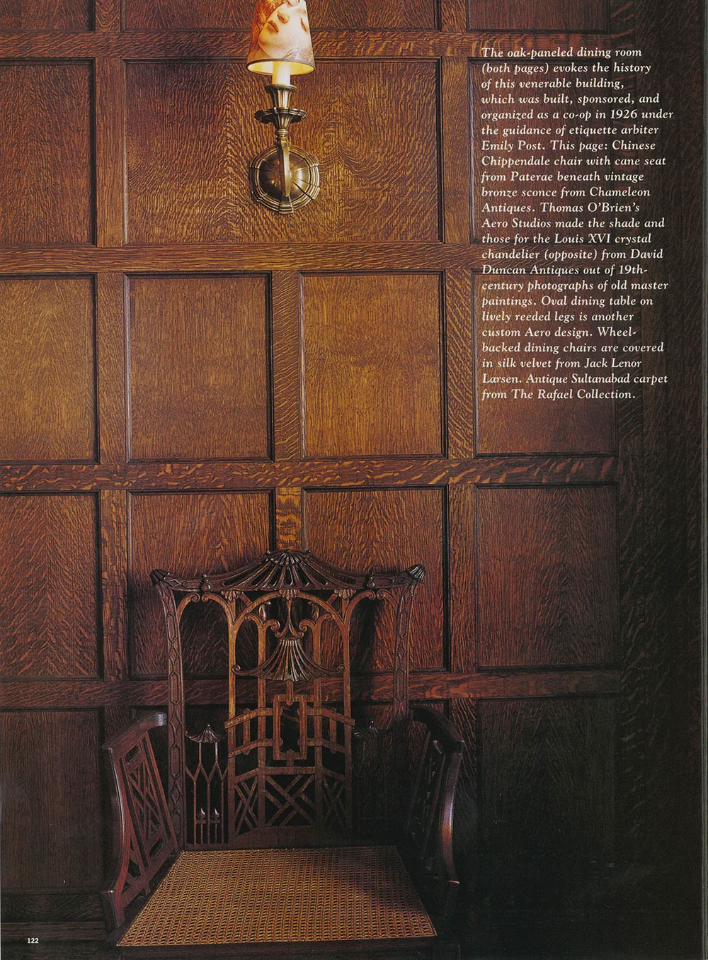 CNR Group custom millwork interior showing a carved Chinese Chippendale chair with cane seat against dark oak-paneled wall beneath bronze sconce with a painted shade.