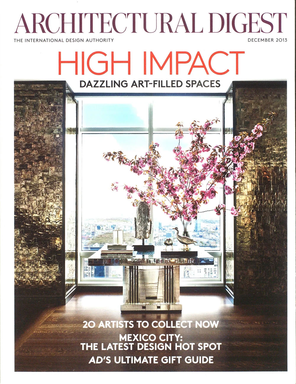 Architectural Digest December 2013 issue that features CNR Group NYC luxury home builders. The cover shows a modern interior with a reflective table, large window with a city view, and pink flowering branches in a vase.