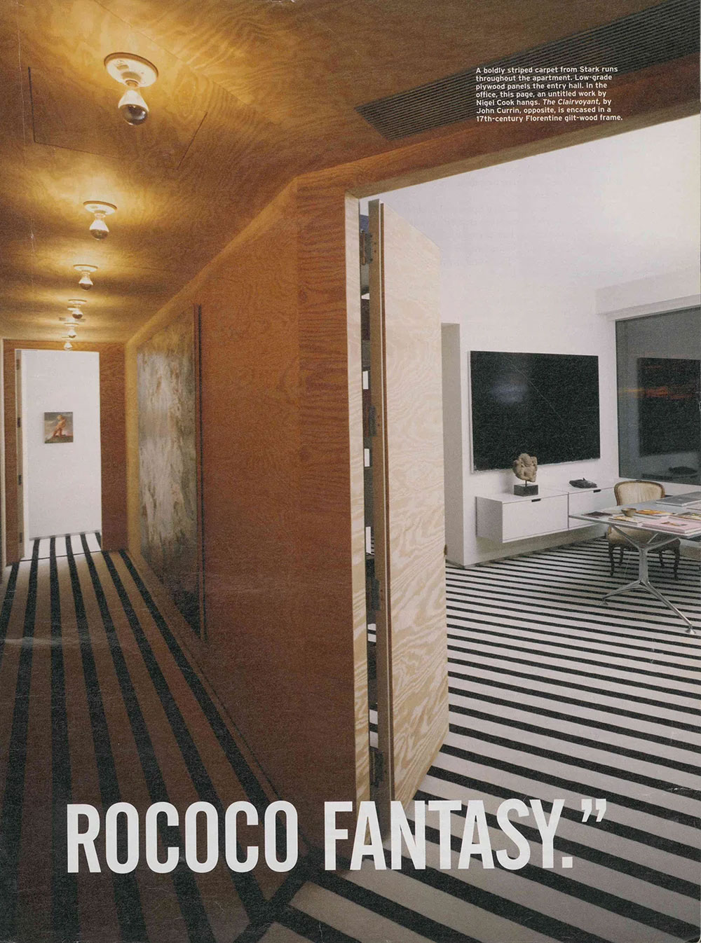Interior of an apartment featuring bold black and white striped carpet, plywood-paneled hallway and an open door leading to a room with white walls, a mounted TV, and modern furnishings: the interior of a CNR Group luxury home build.