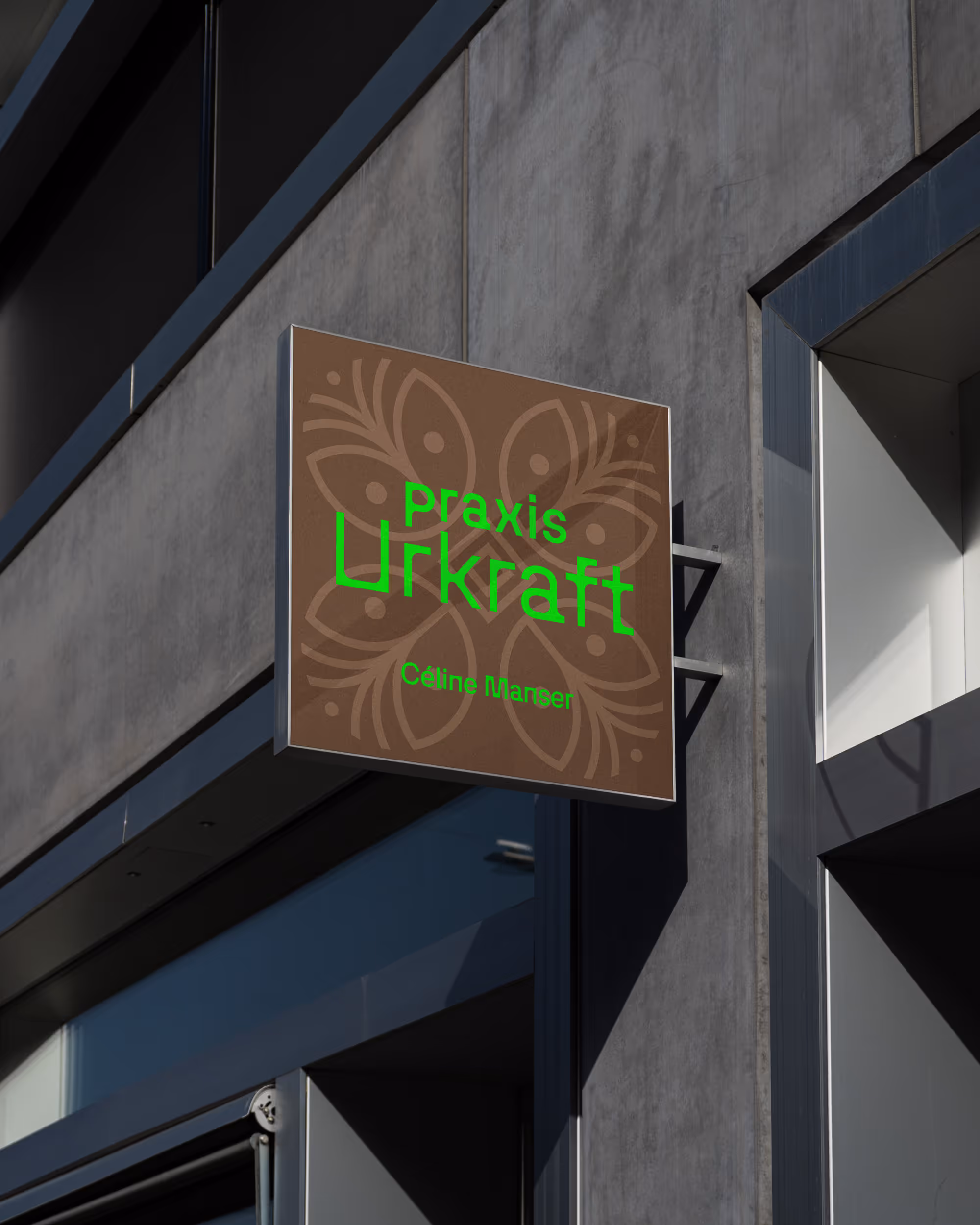 Leuchtschild der Praxis Urkraft von Céline Manser an einer Gebäudefassade, mit braunem Hintergrund, floralem Muster und grün leuchtender Schrift.