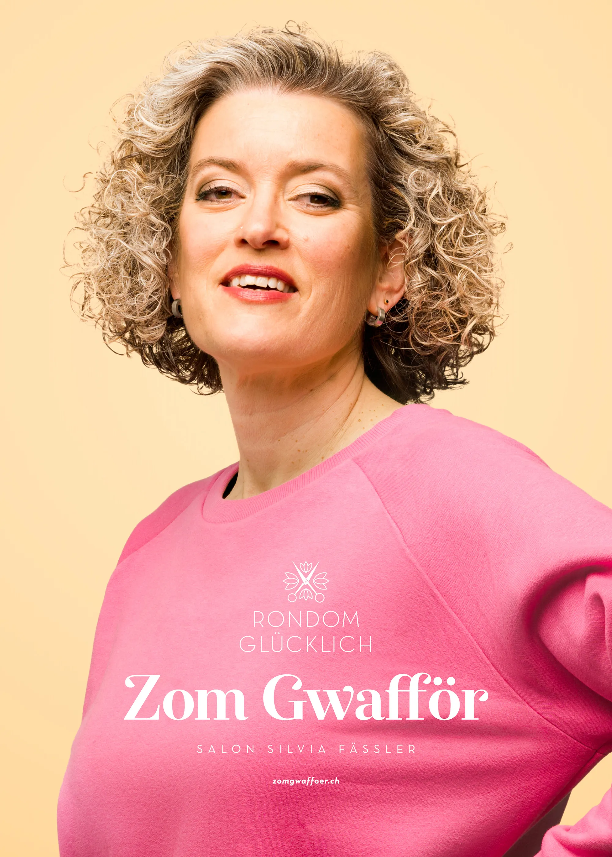 Selbstbewusste Frau mit lockigem Haar im rosafarbenen Shirt vor warmem Hintergrund – Zom Gwafför Kampagnenbild.