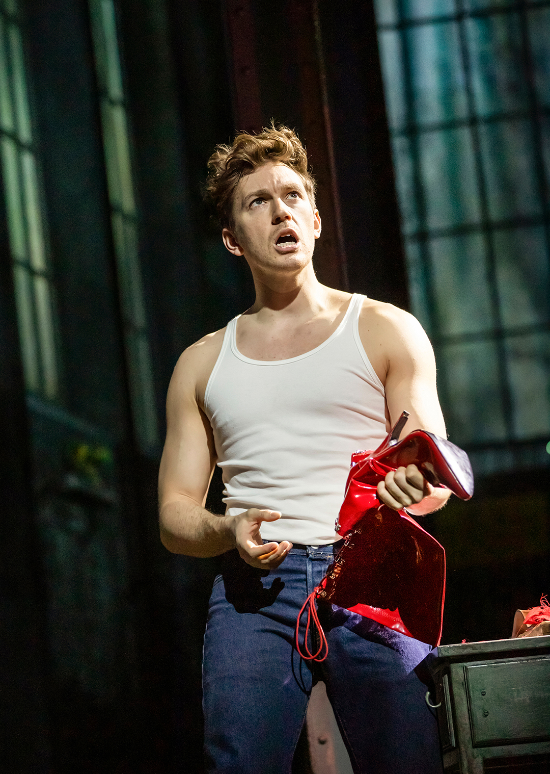 Charlie in der Fabrik mit einem halbfertigen Schuh in der Hand