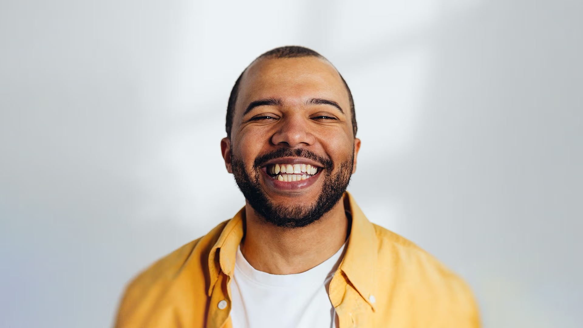 Man wearing yellow shirt and smiling