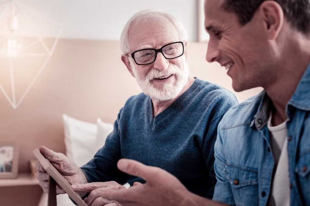 Older man and younger man talk about a picture in a photo frame
