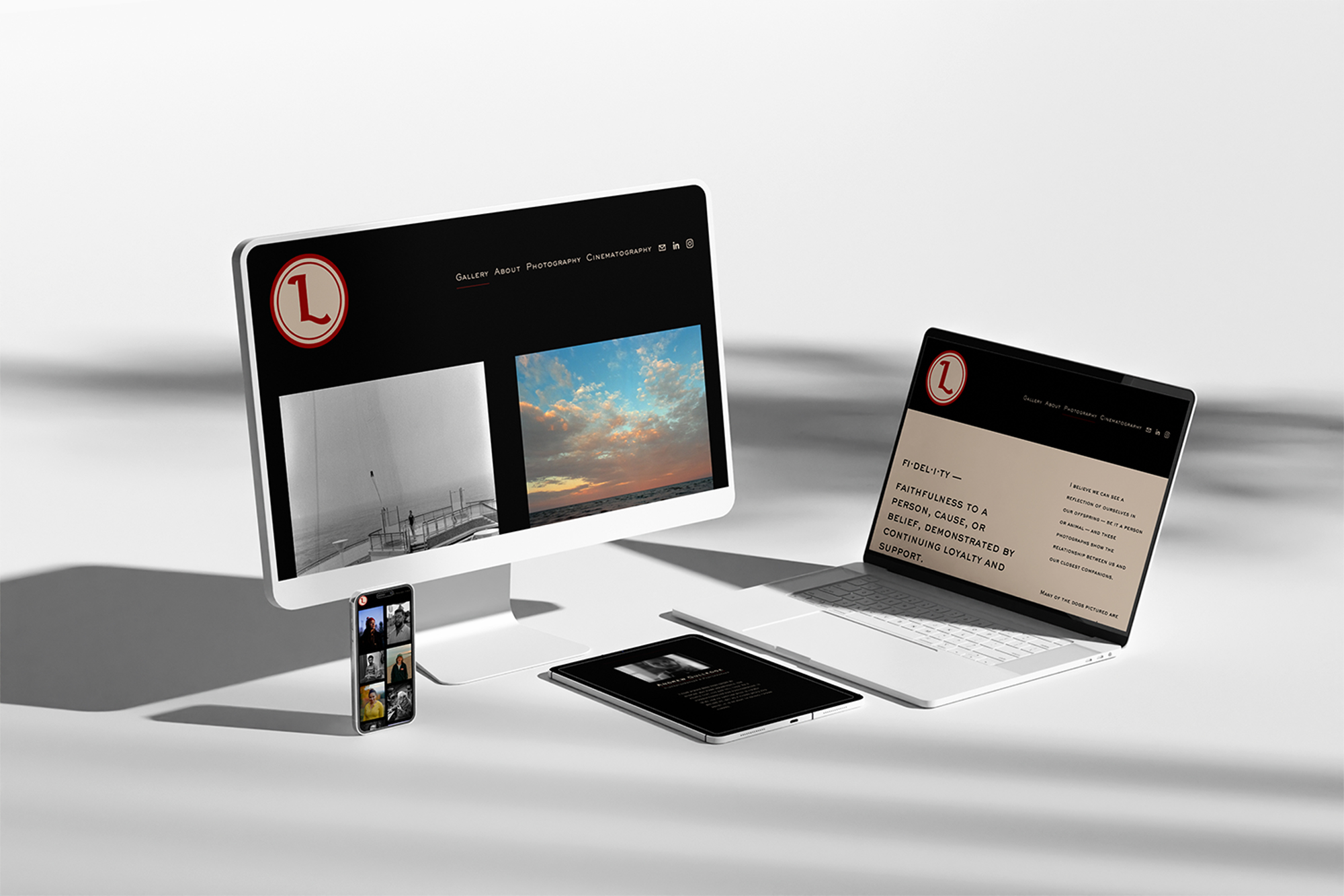 A desktop computer, smartphone, tablet, and laptop displaying a black-themed photography website with a red circular logo and image galleries.