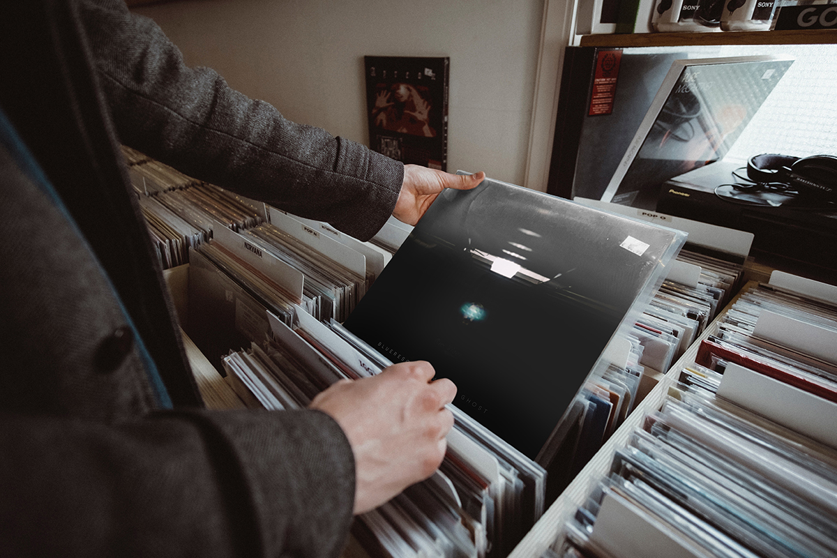 person looking at vinyl record from shelf