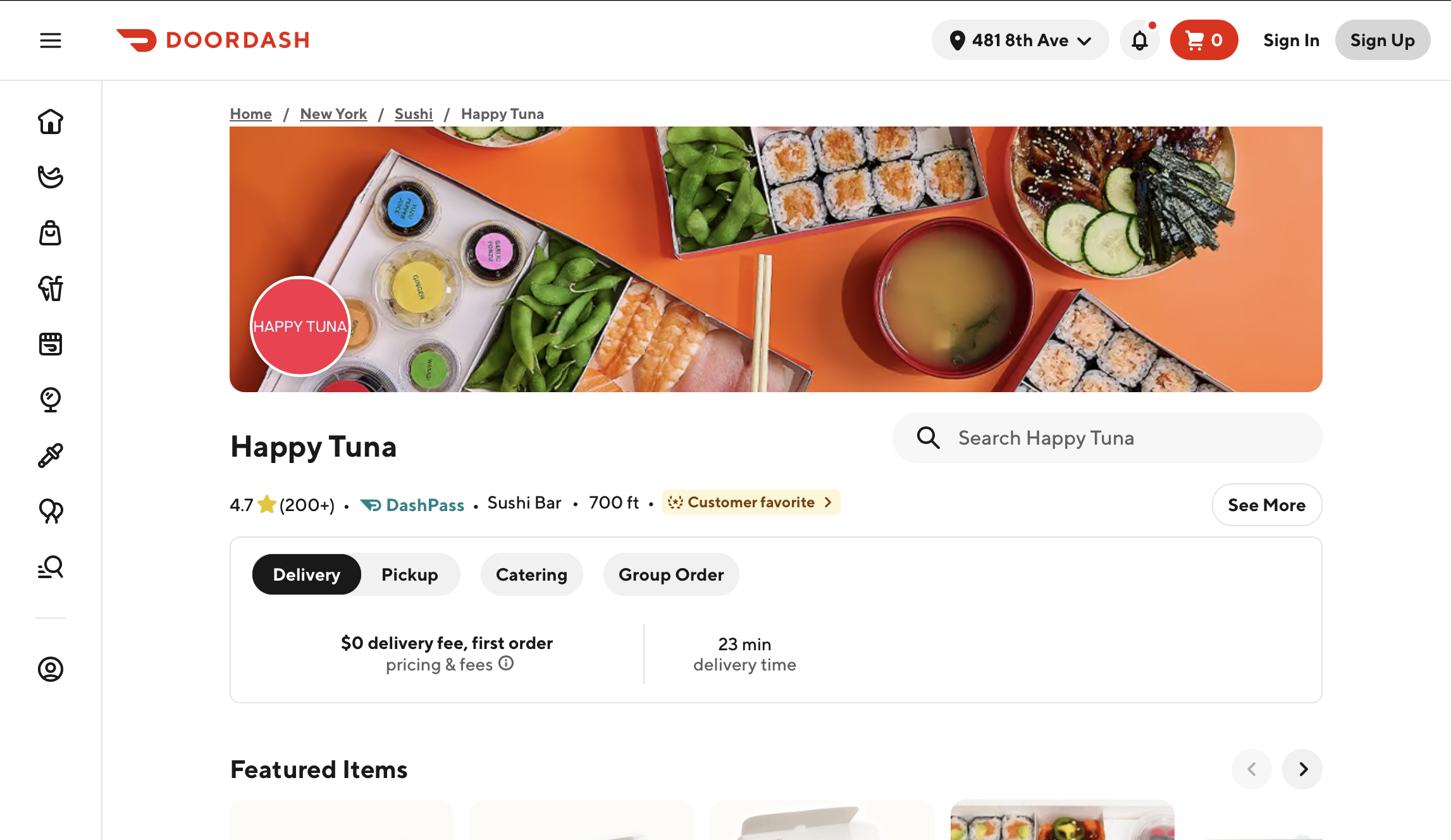 Top view of sushi platter with edamame, miso soup, assorted sushi rolls, and a bowl of grilled eel with cucumbers on an orange background.