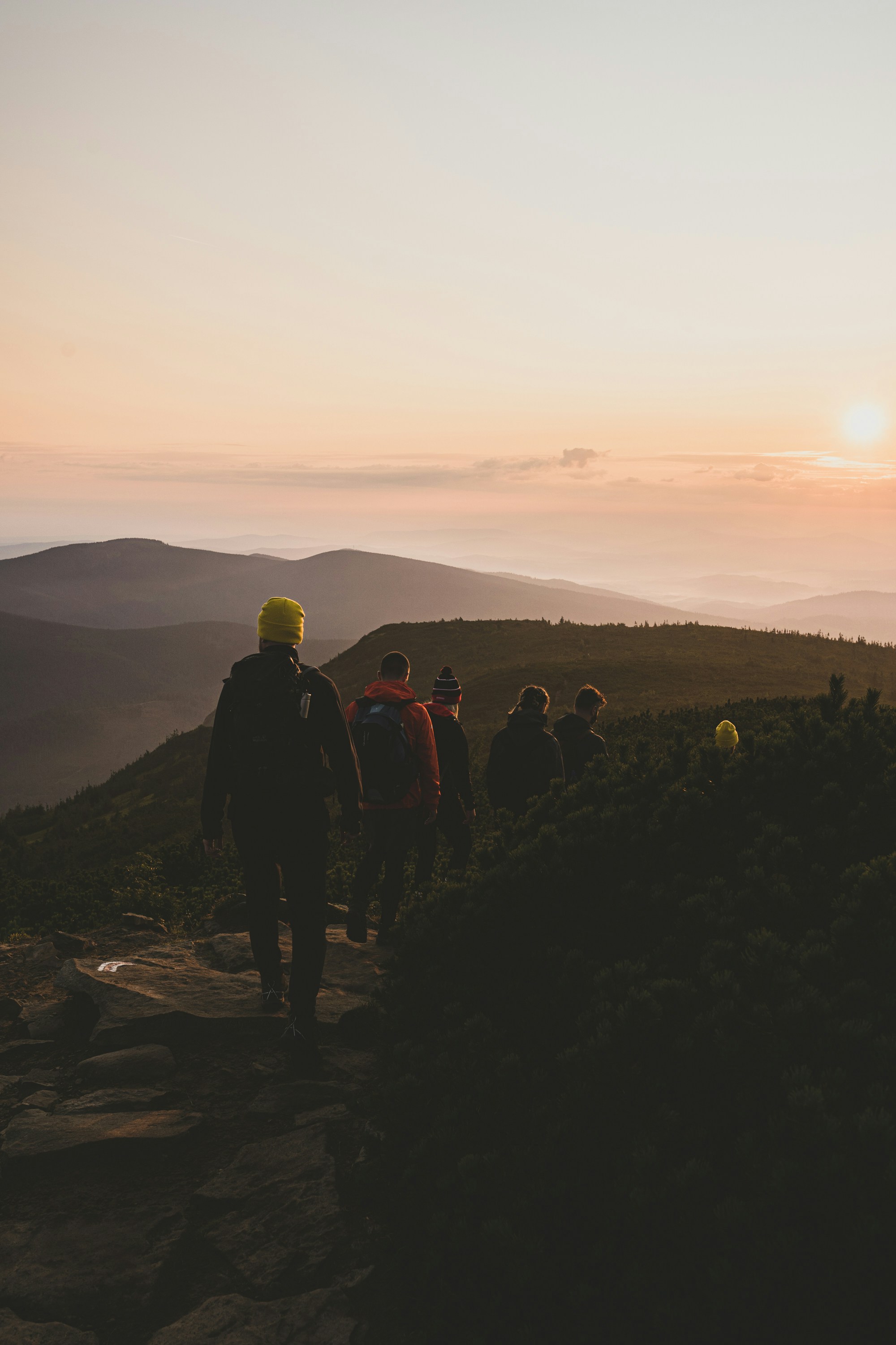 Person adjusting colorful illuminated pegs on a large interactive light pegboard.