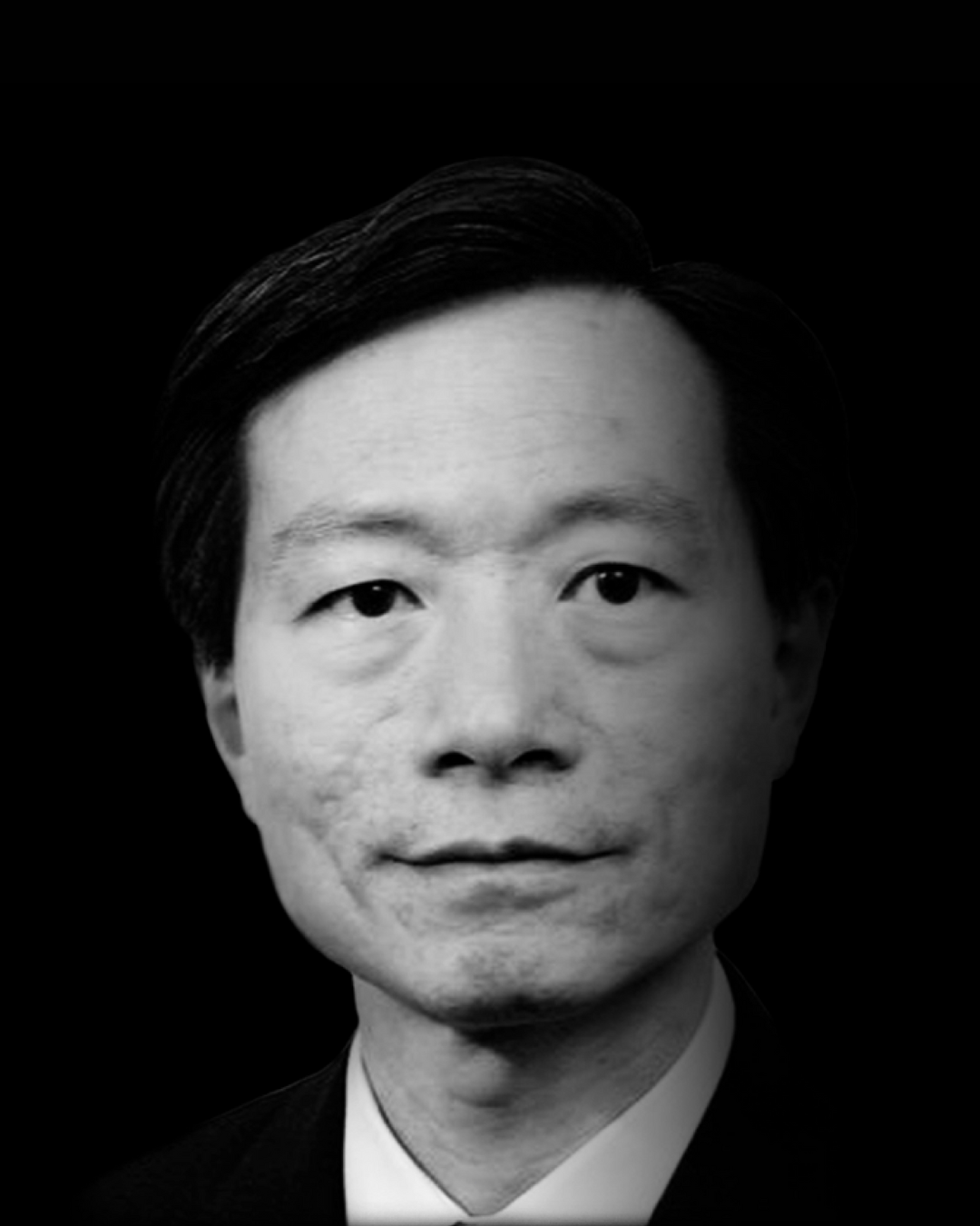 Black and white headshot of an Asian man in a suit and tie against a black background.