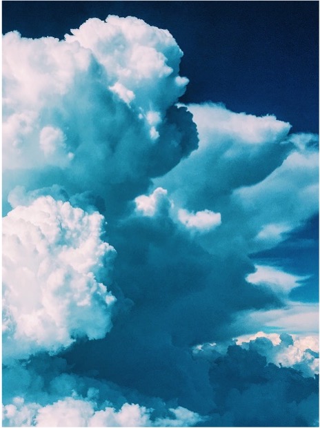 Large, fluffy white clouds against a deep blue sky.