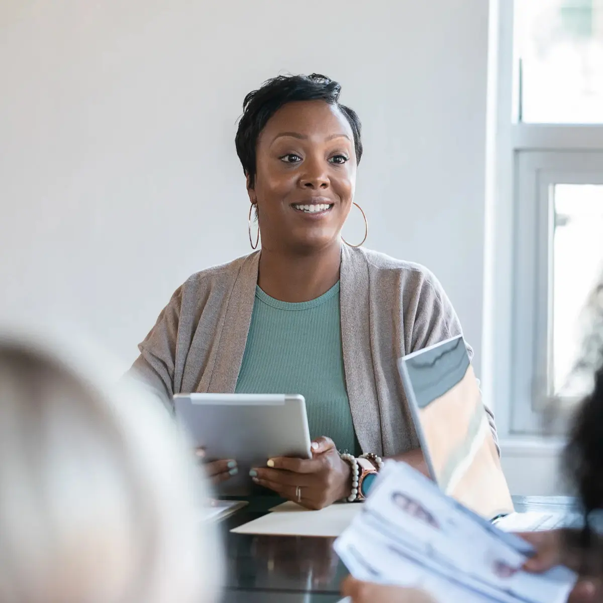 a woman smiling while listening during a meeting.