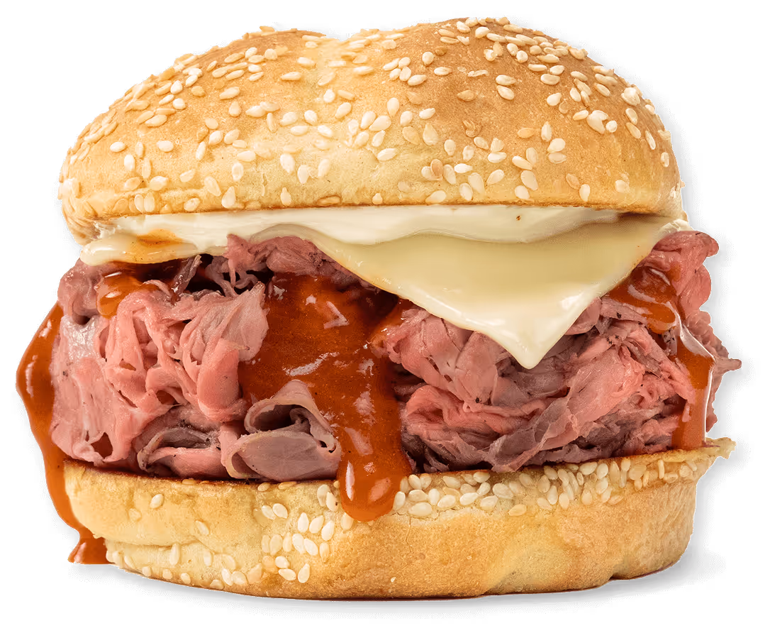 Sandwich with roast beef, melted cheese, and barbecue sauce in a sesame seed bun.