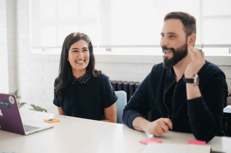 A girl smiles while a guy talks.