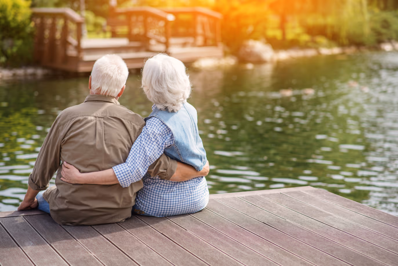 Seniors sitting by lake stock image